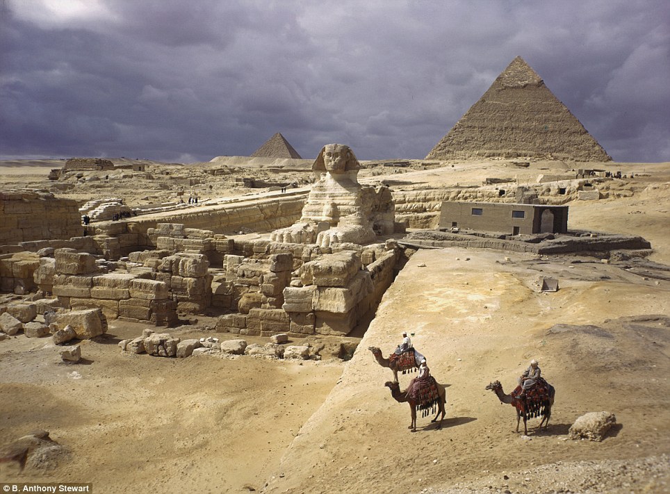 Landmark: In this iconic 1938 image, three figures astride camels behold the majesty of the Great Sphinx and the pyramids of Giza, Egypt